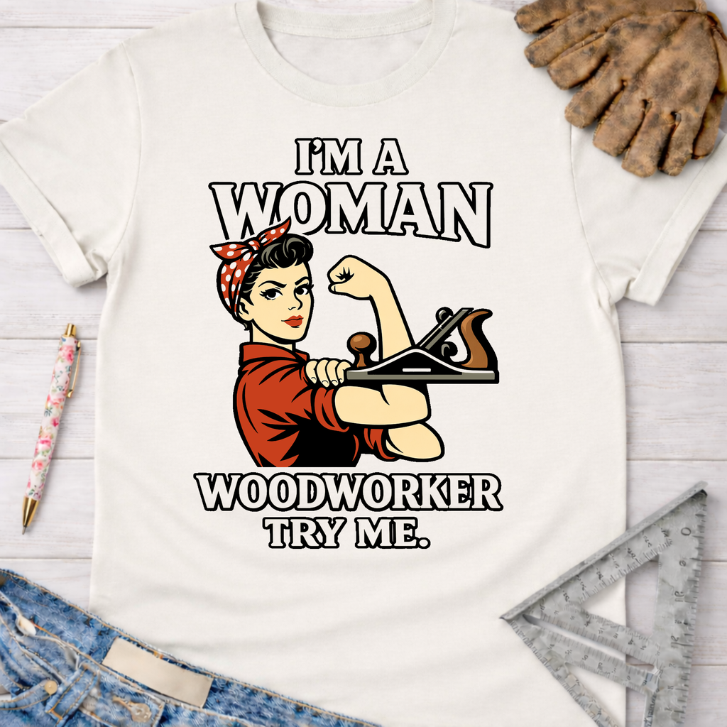 White cotton tee with "I'm A Woman Woodworker Try Me" Rosie Riveter graphic holding a hand plane.