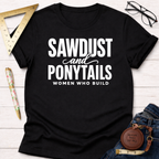 Black cotton t-shirt with "SAWDUST and PONYTAILS WOMEN WHO BUILD" in white text.