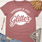 Women's funny woodworking graphic tee shirt for female woodworkers, makers, and DIY builders — Sawdust & Ponytails. Dusty rose cotton tee with "Sawdust Is Just Glitter" graphic.