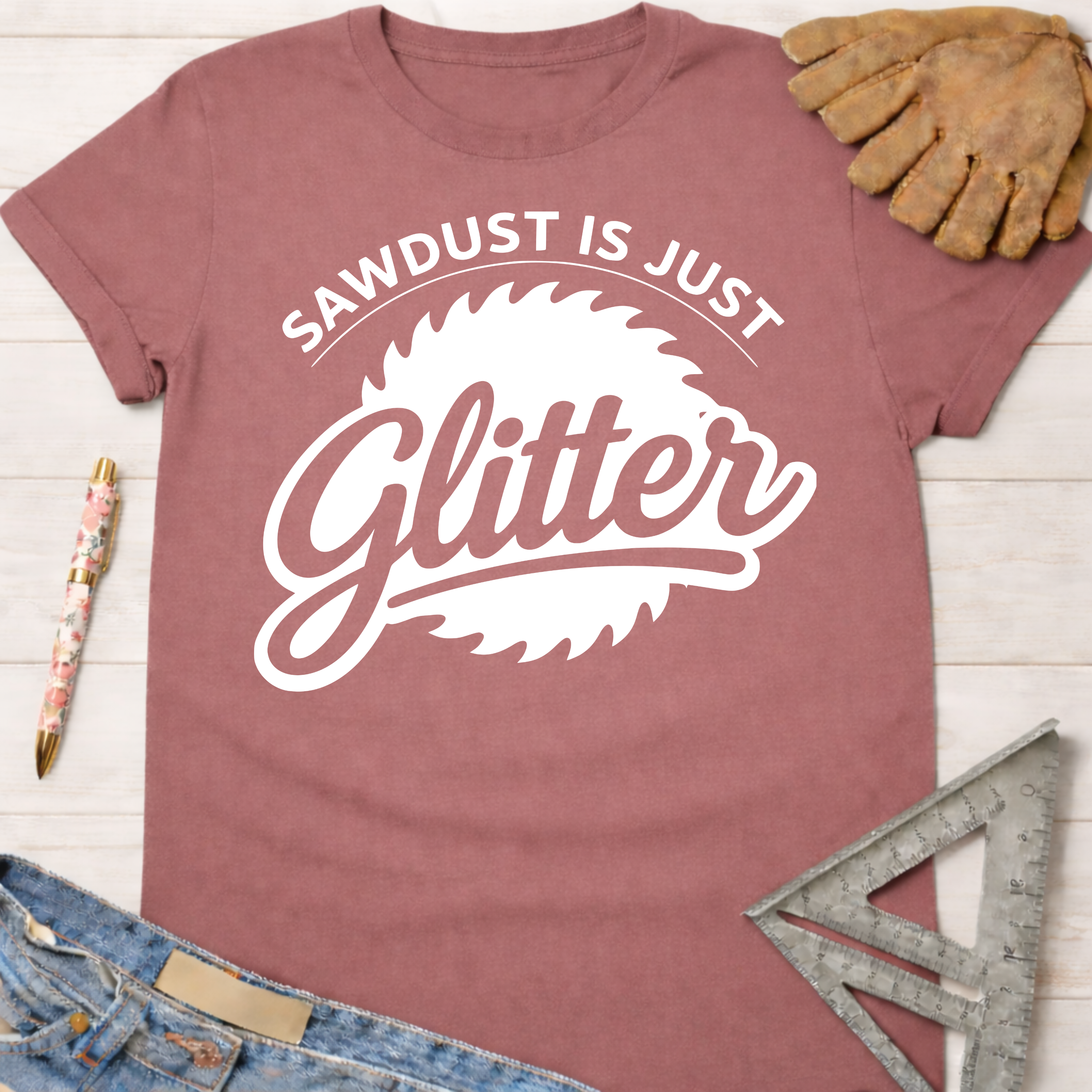 Women's funny woodworking graphic tee shirt for female woodworkers, makers, and DIY builders — Sawdust & Ponytails. Dusty rose cotton tee with "Sawdust Is Just Glitter" graphic.