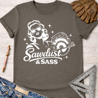 Women's funny woodworking graphic tee shirt for female woodworkers, makers, and DIY builders — Sawdust & Ponytails. Dark gray cotton tee with white graphic of a retro woman holding a circular saw, "Sawdust & Sass" text.