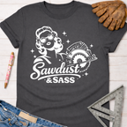 Women's funny woodworking graphic tee shirt for female woodworkers, makers, and DIY builders — Sawdust & Ponytails. Dark gray cotton tee with white "Sawdust & Sass" graphic featuring a retro woman holding a circular saw.
