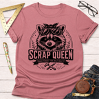 Dusty rose cotton t-shirt with a black graphic of a raccoon wearing sunglasses and a bandana, text "SCRAP QUEEN".