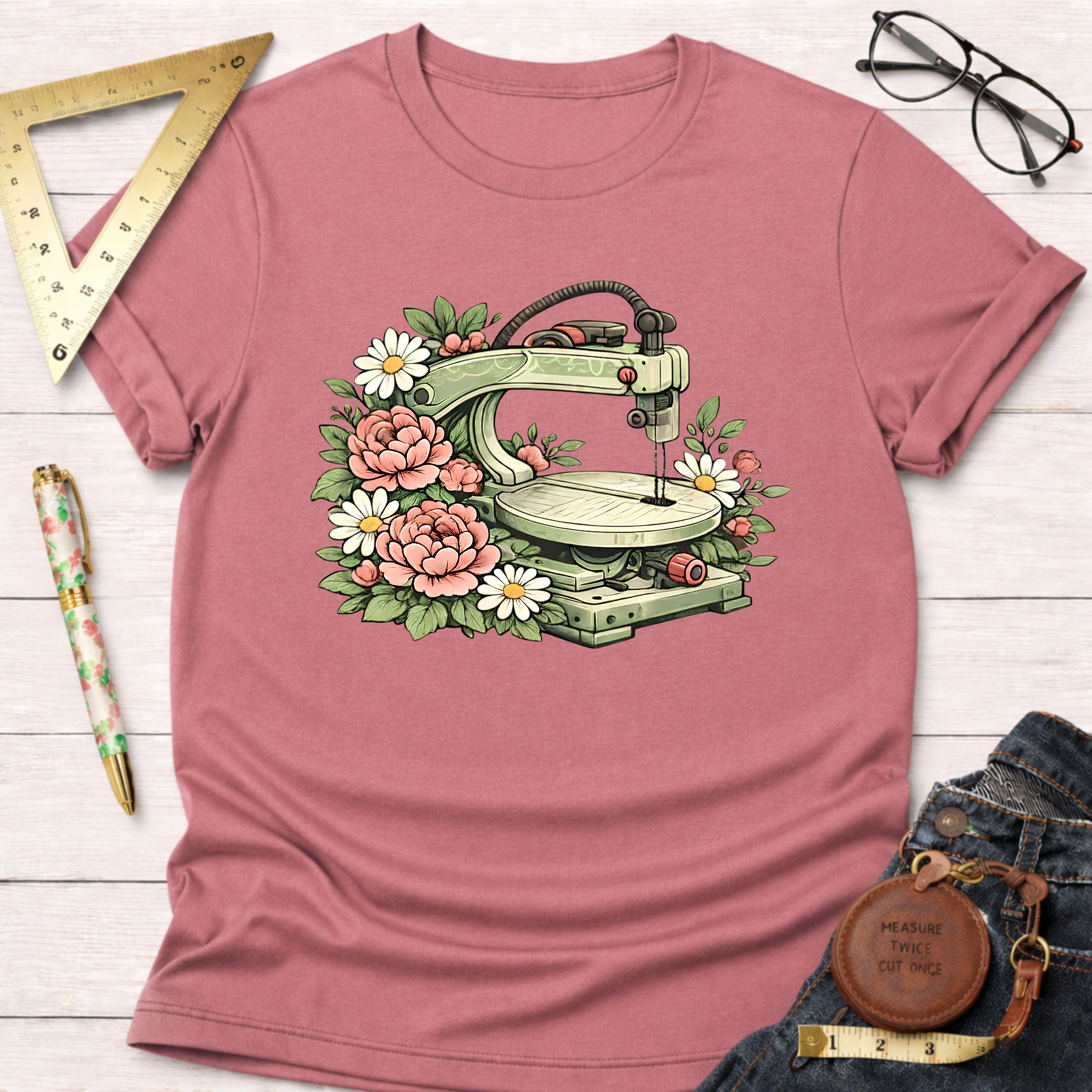 Pink t-shirt with a scroll saw surrounded by pink roses and white daisies.