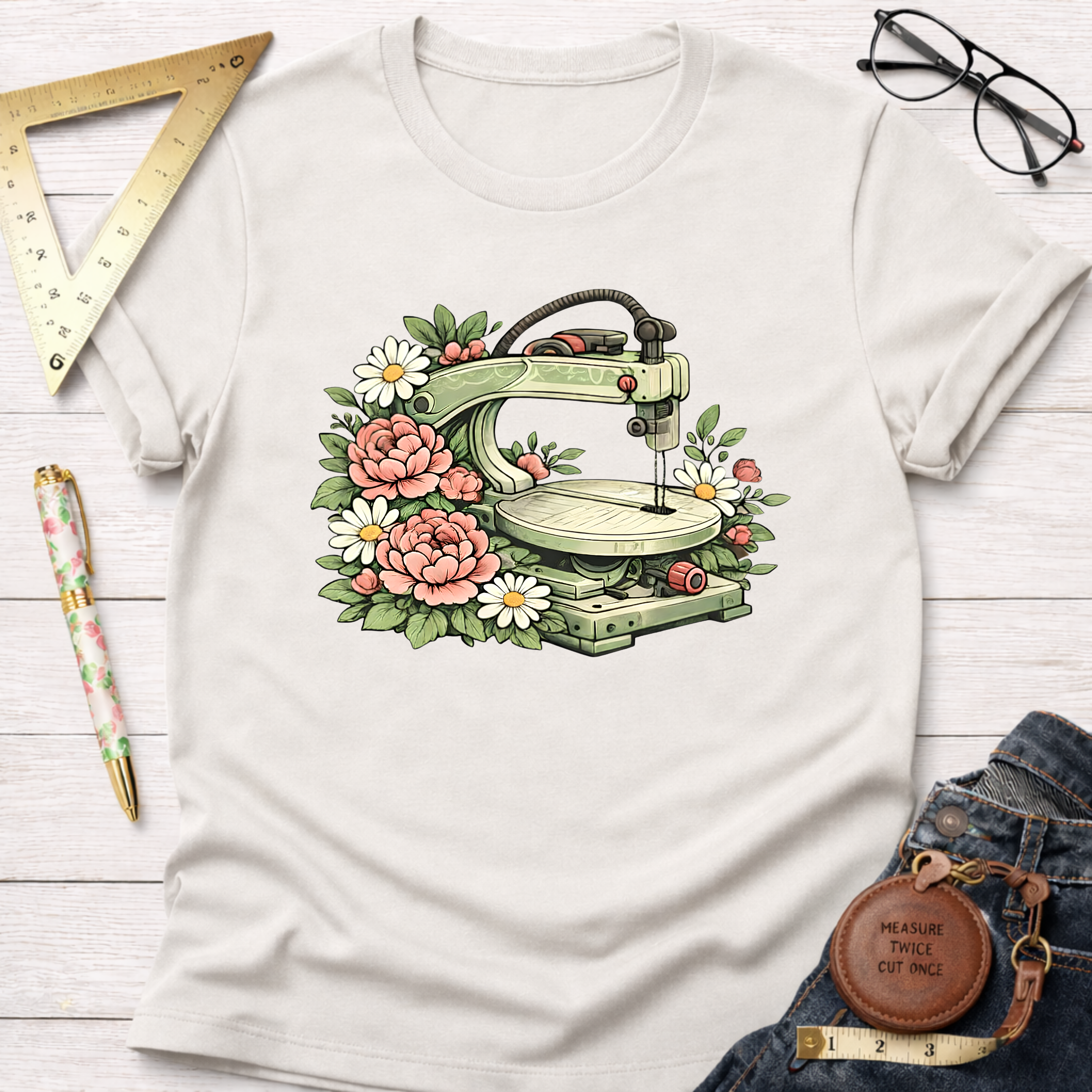 Cream t-shirt with a vintage scroll saw surrounded by pink peonies and white daisies.