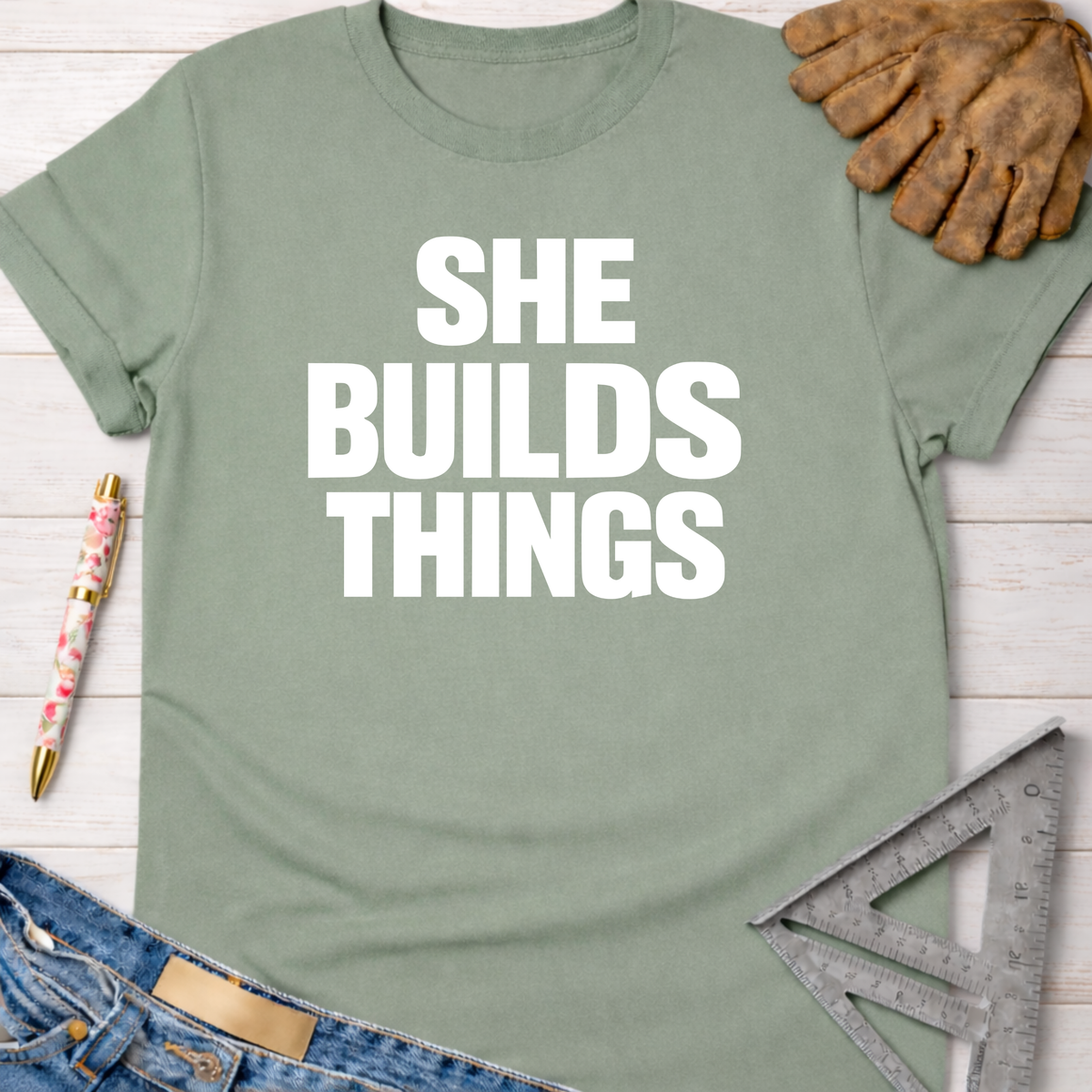 Sage green "SHE BUILDS THINGS" graphic tee, women's funny woodworking shirt for makers and DIY builders — Sawdust & Ponytails.