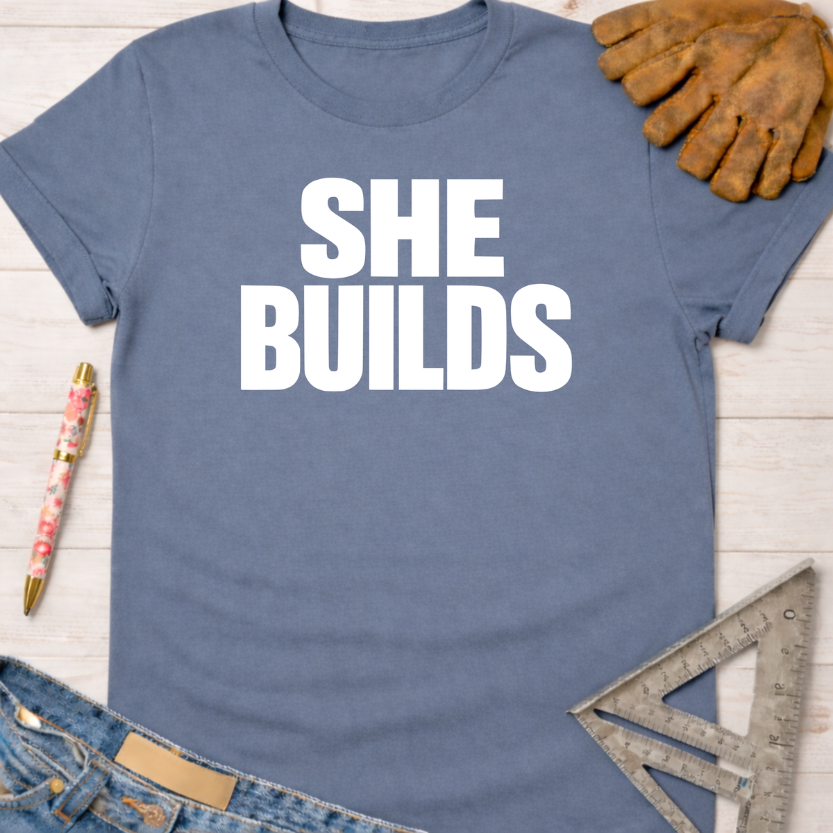Blue "SHE BUILDS" graphic tee for female woodworkers, makers, and DIY builders — Sawdust & Ponytails.