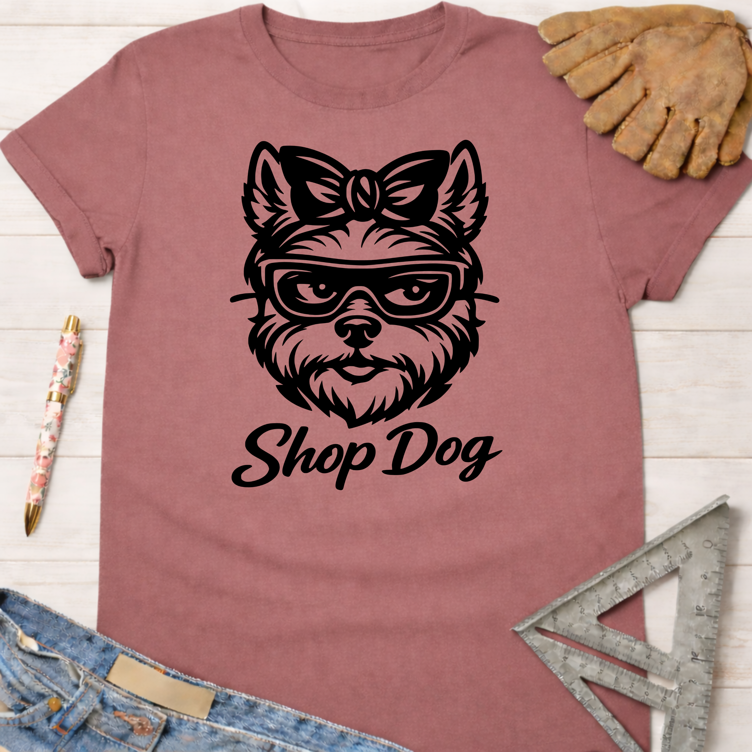 Women's funny woodworking graphic tee shirt for female woodworkers, makers, and DIY builders — Sawdust & Ponytails. Mauve t-shirt with a black "Shop Dog" graphic of a dog wearing glasses and a bow.