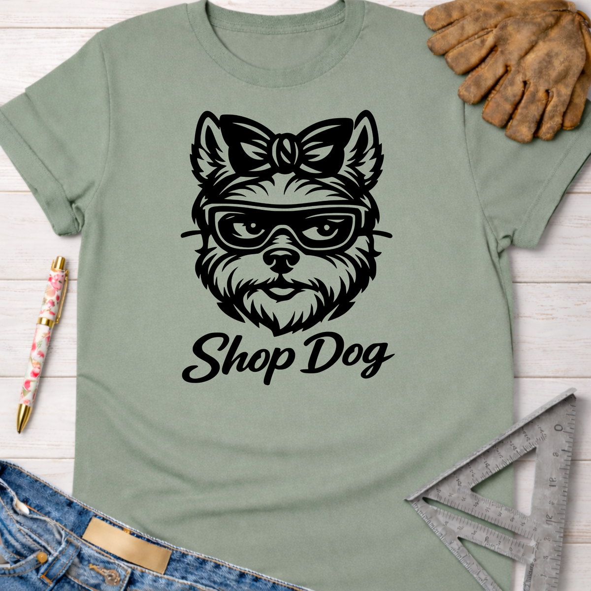 Women's funny woodworking graphic tee shirt for female woodworkers, makers, and DIY builders — Sawdust & Ponytails. Sage green tee with black "Shop Dog" graphic of a dog wearing glasses and a bow.