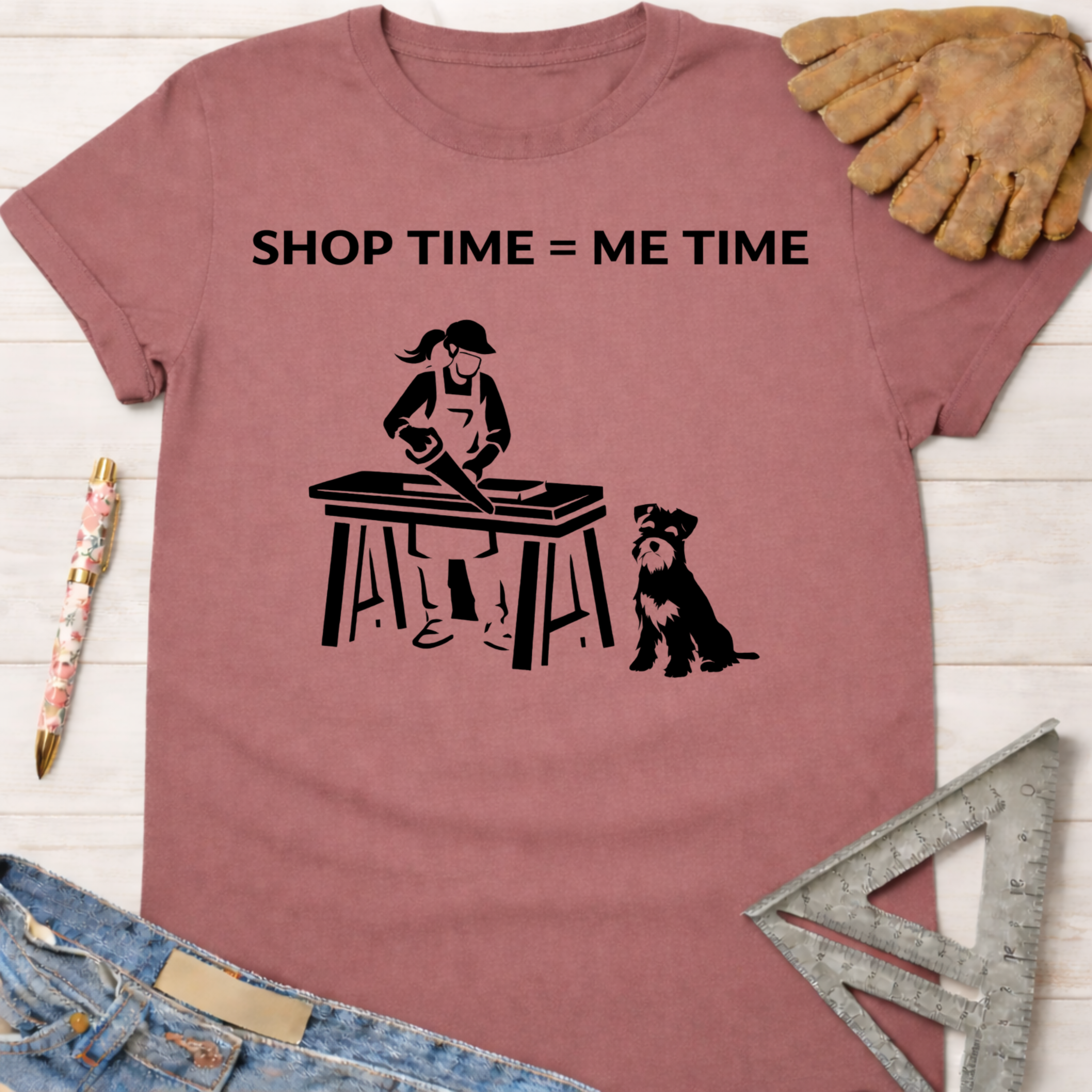 Women's funny woodworking graphic tee shirt for female woodworkers, makers, and DIY builders — Sawdust & Ponytails. Mauve t-shirt with "SHOP TIME = ME TIME" text, a woman sawing wood, and a dog.