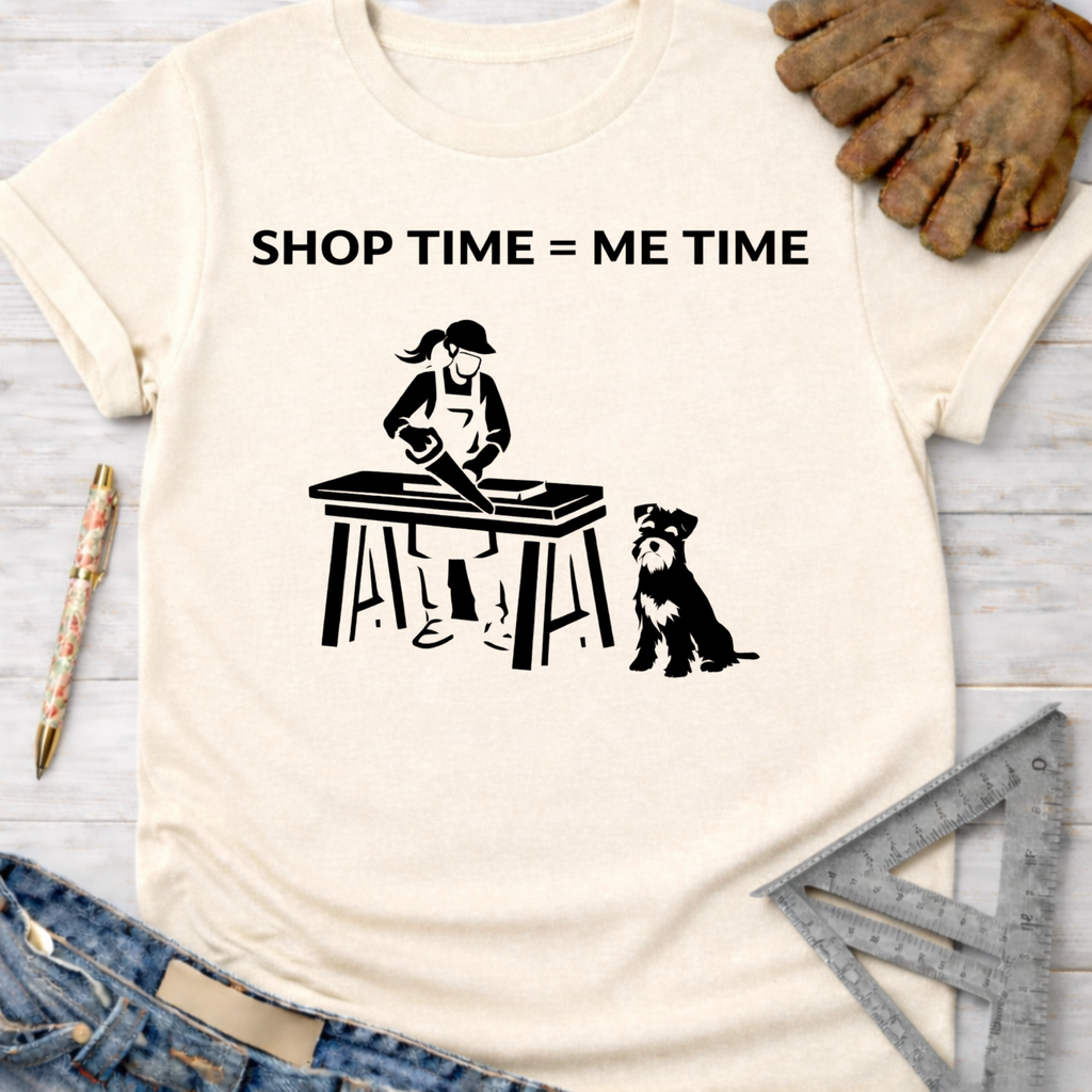 Women's funny woodworking graphic tee shirt for female woodworkers, makers, and DIY builders — Sawdust & Ponytails. Cream short-sleeve t-shirt with "SHOP TIME = ME TIME" text and a graphic of a woman sawing wood with a dog.
