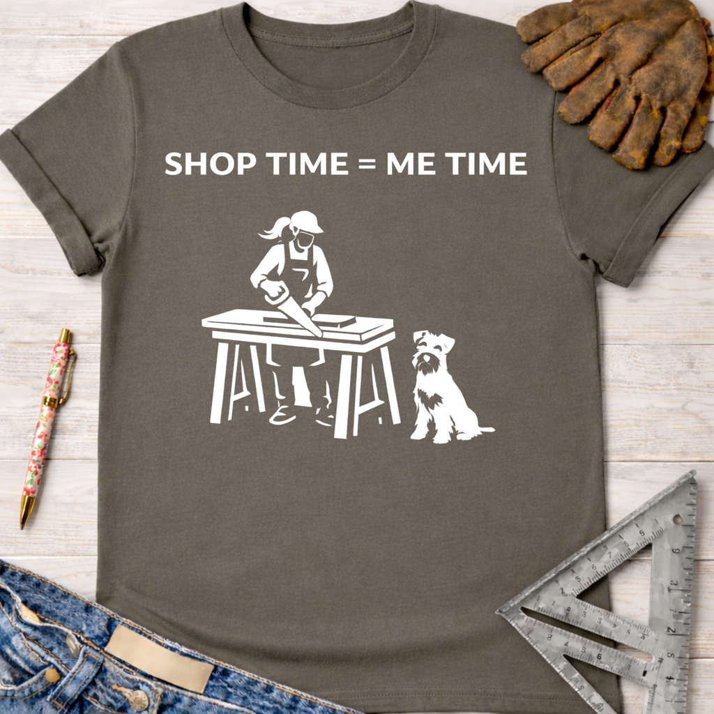Women's funny woodworking graphic tee shirt for female woodworkers, makers, and DIY builders — Sawdust & Ponytails. Dark gray t-shirt with "SHOP TIME = ME TIME" text and a graphic of a woman sawing wood with a dog.