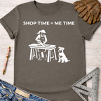 Women's funny woodworking graphic tee shirt for female woodworkers, makers, and DIY builders — Sawdust & Ponytails. Dark gray t-shirt with "SHOP TIME = ME TIME" text and a graphic of a woman sawing wood with a dog.