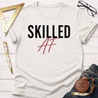 White cotton t-shirt with "Skilled AF" in black and pink text, styled with jeans, ruler, and glasses.