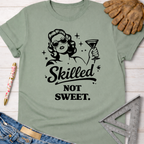 Women's funny woodworking graphic tee shirt for female woodworkers, makers, and DIY builders — Sawdust & Ponytails. Sage green t-shirt with "Skilled Not Sweet" graphic.