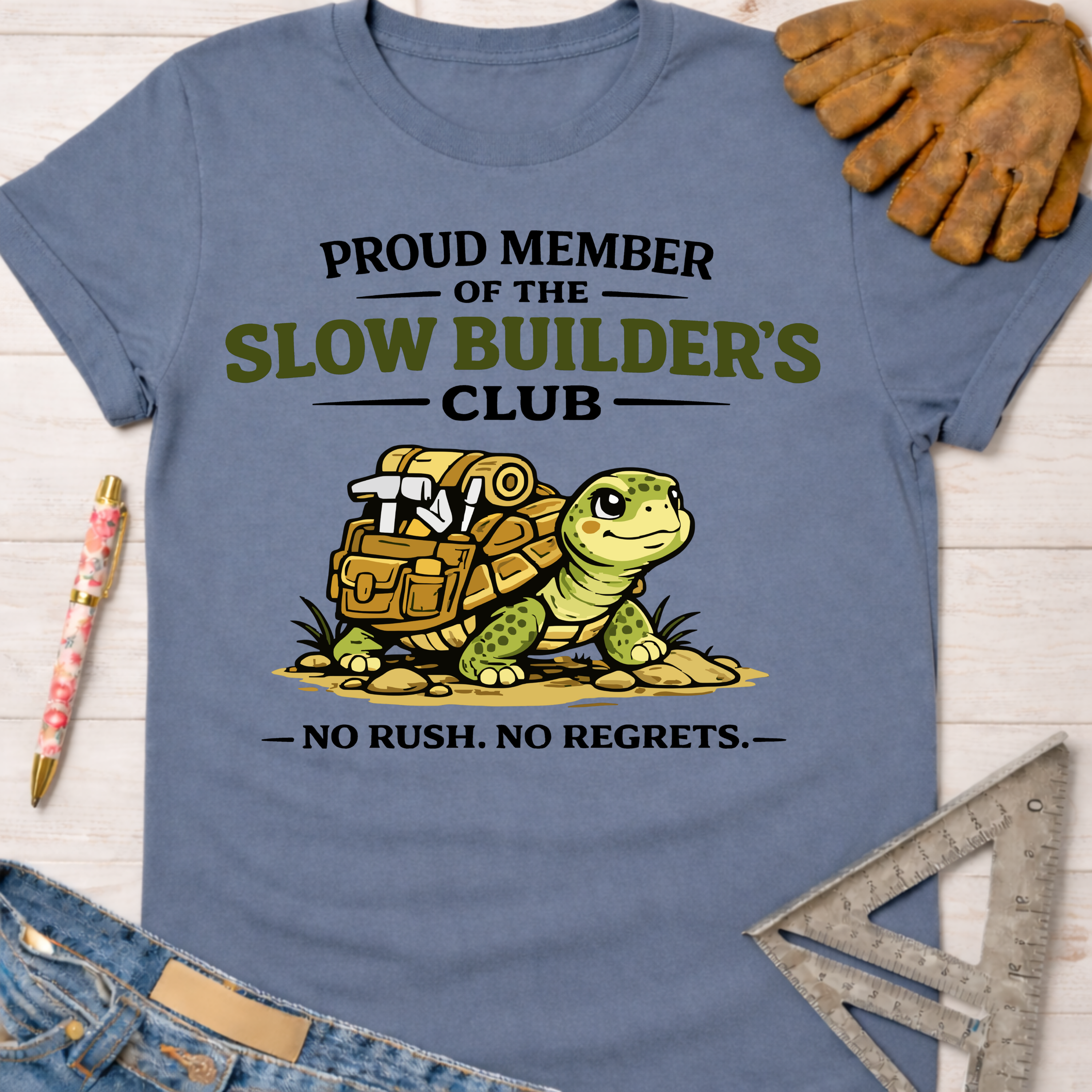 Women's funny woodworking graphic tee shirt for female woodworkers, makers, and DIY builders — Sawdust & Ponytails. Blue cotton tee with "Slow Builder's Club" turtle graphic.