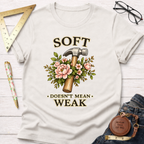 Cream t-shirt with "Soft Doesn't Mean Weak" text, a hammer, and pink floral design.
