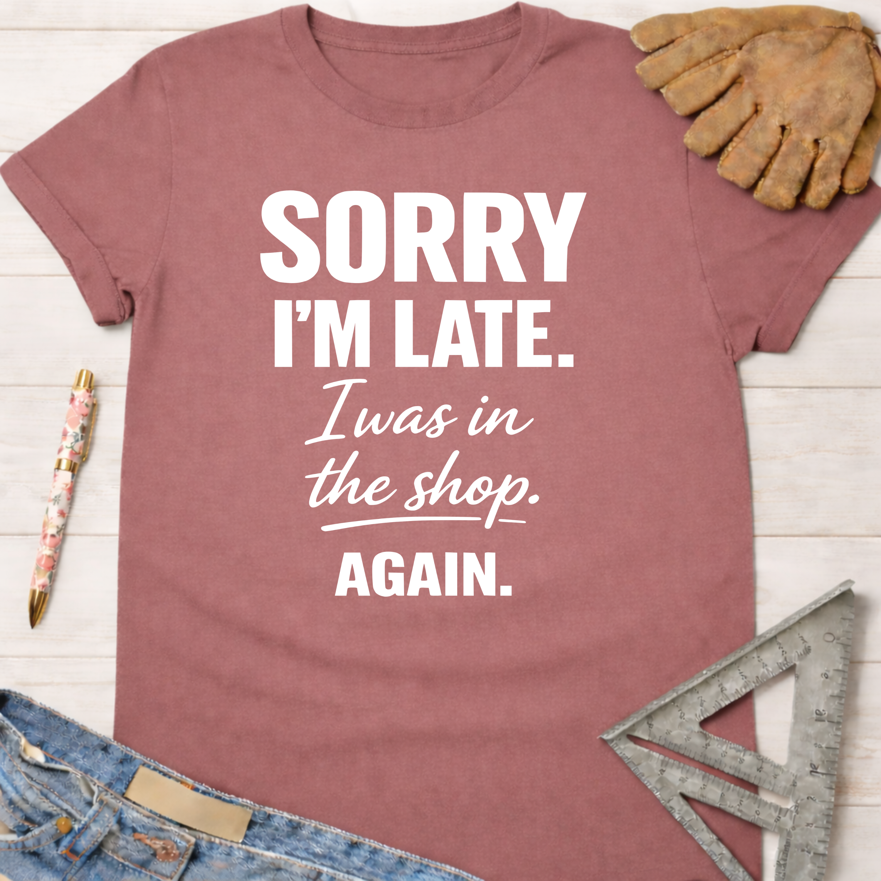 Women's funny woodworking graphic tee shirt for female woodworkers, makers, and DIY builders — Sawdust & Ponytails. Mauve cotton t-shirt with "Sorry I'm Late. I was in the shop. AGAIN." in white text.