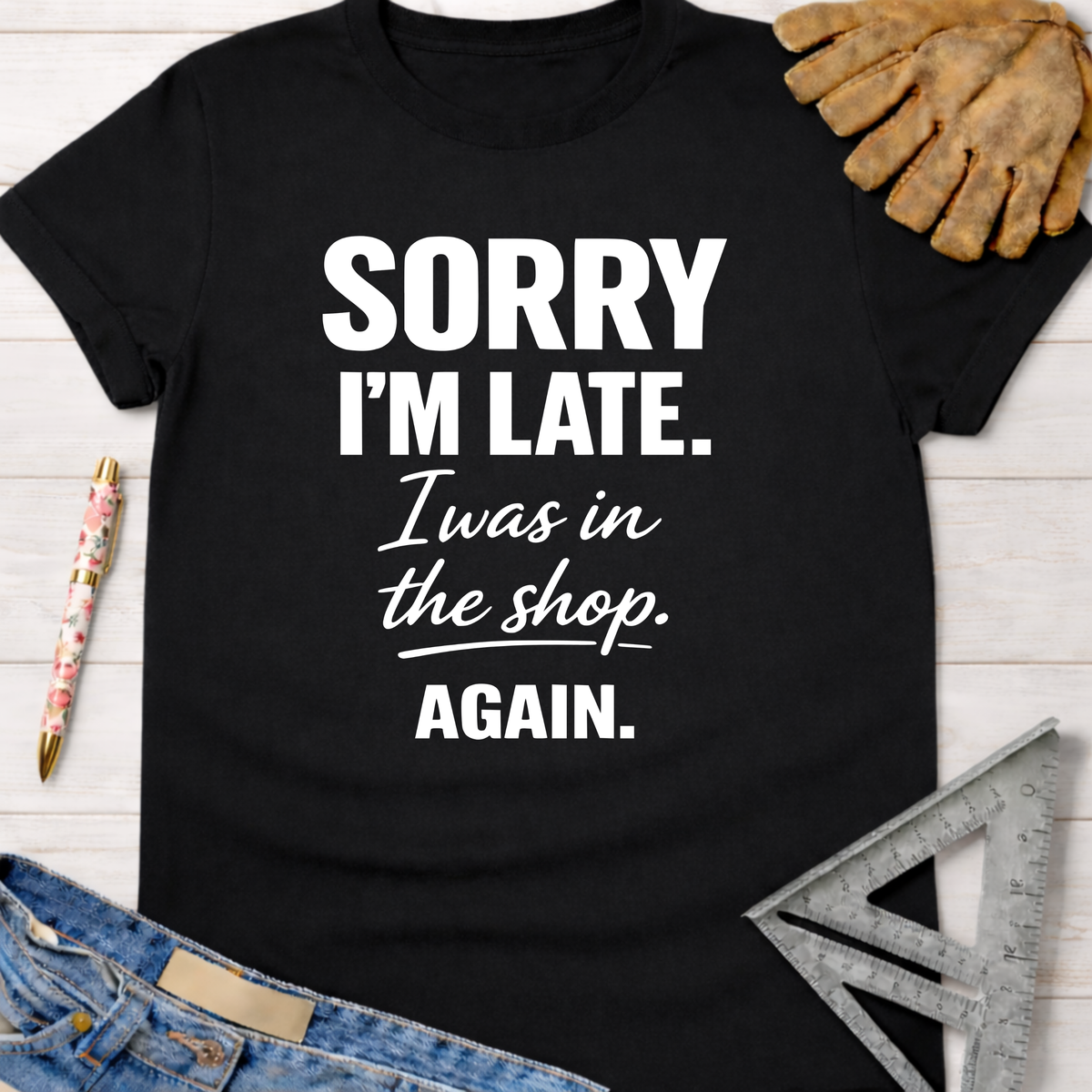 Women's funny woodworking graphic tee shirt for female woodworkers, makers, and DIY builders — Sawdust & Ponytails. Black cotton tee with "Sorry I'm Late. I was in the shop. AGAIN." in white text.