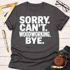 Women's funny woodworking graphic tee shirt for female woodworkers, makers, and DIY builders — Sawdust & Ponytails. Dark gray tee with "SORRY. CAN'T. WOODWORKING. BYE." in white text.