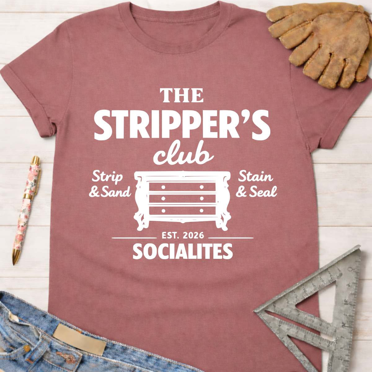 Women's funny woodworking graphic tee shirt for female woodworkers, makers, and DIY builders — Sawdust & Ponytails. Mauve t-shirt with "The Stripper's Club Socialites" graphic.