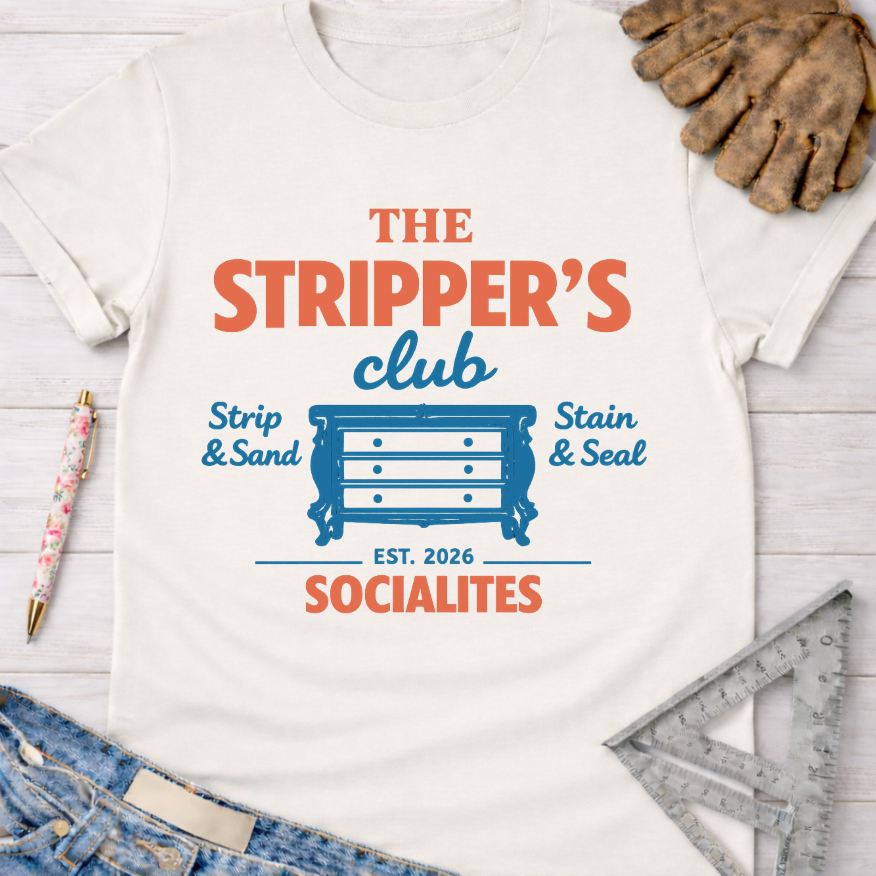 Women's funny woodworking graphic tee shirt for female woodworkers, makers, and DIY builders — Sawdust & Ponytails. White cotton tee with "The Stripper's Club Socialites" graphic featuring a blue dresser.
