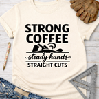 Women's funny woodworking graphic tee shirt for female woodworkers, makers, and DIY builders — Sawdust & Ponytails. Cream t-shirt with "Strong Coffee Steady Hands Straight Cuts" graphic.