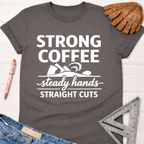 Women's funny woodworking graphic tee shirt for female woodworkers, makers, and DIY builders — Sawdust & Ponytails. Dark gray cotton tee with "Strong Coffee Steady Hands Straight Cuts" graphic.