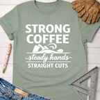 Women's funny woodworking graphic tee shirt for female woodworkers, makers, and DIY builders — Sawdust & Ponytails. Sage green t-shirt with "Strong Coffee Steady Hands Straight Cuts" graphic.