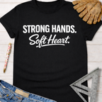 Black cotton "Strong Hands. Soft Heart." graphic tee with work gloves, jeans, and a ruler. Women's funny woodworking graphic tee shirt for female woodworkers, makers, and DIY builders — Sawdust & Ponytails.