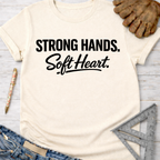 Women's funny woodworking graphic tee shirt for female woodworkers, makers, and DIY builders — Sawdust & Ponytails. Cream cotton tee with "Strong Hands. Soft Heart." in black text.