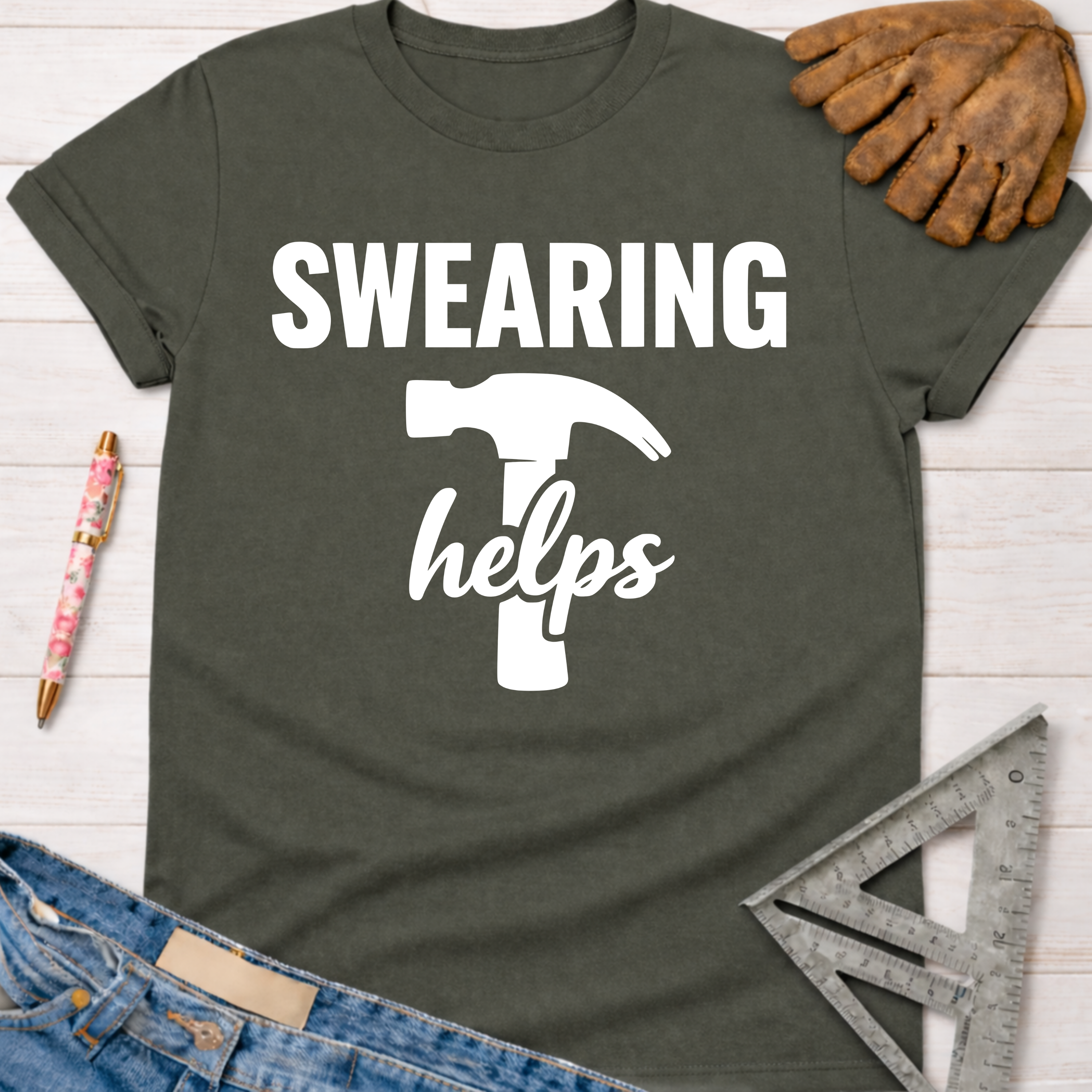 Women's funny woodworking graphic tee shirt for female woodworkers, makers, and DIY builders — Sawdust & Ponytails. Dark gray tee with "SWEARING helps" and hammer graphic.