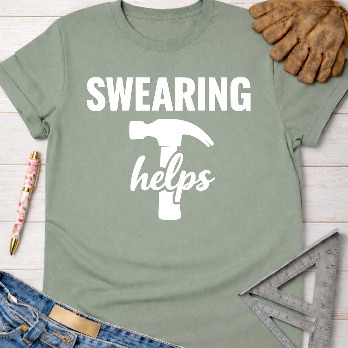 Women's funny woodworking graphic tee shirt for female woodworkers, makers, and DIY builders — Sawdust & Ponytails. Sage green cotton tee with "SWEARING helps" and a hammer graphic.