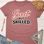 Women's funny woodworking graphic tee shirt for female woodworkers, makers, and DIY builders — Sawdust & Ponytails. Mauve cotton tee with "Sweet But Skilled" text.