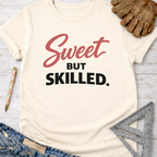 Women's funny woodworking graphic tee shirt for female woodworkers, makers, and DIY builders — Sawdust & Ponytails. Cream t-shirt with "Sweet BUT SKILLED." in red and black text.