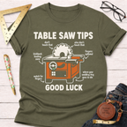 Women's funny woodworking graphic tee shirt for female woodworkers, makers, and DIY builders — Sawdust & Ponytails. Olive green cotton t-shirt with a humorous "Table Saw Tips Good Luck" graphic.
