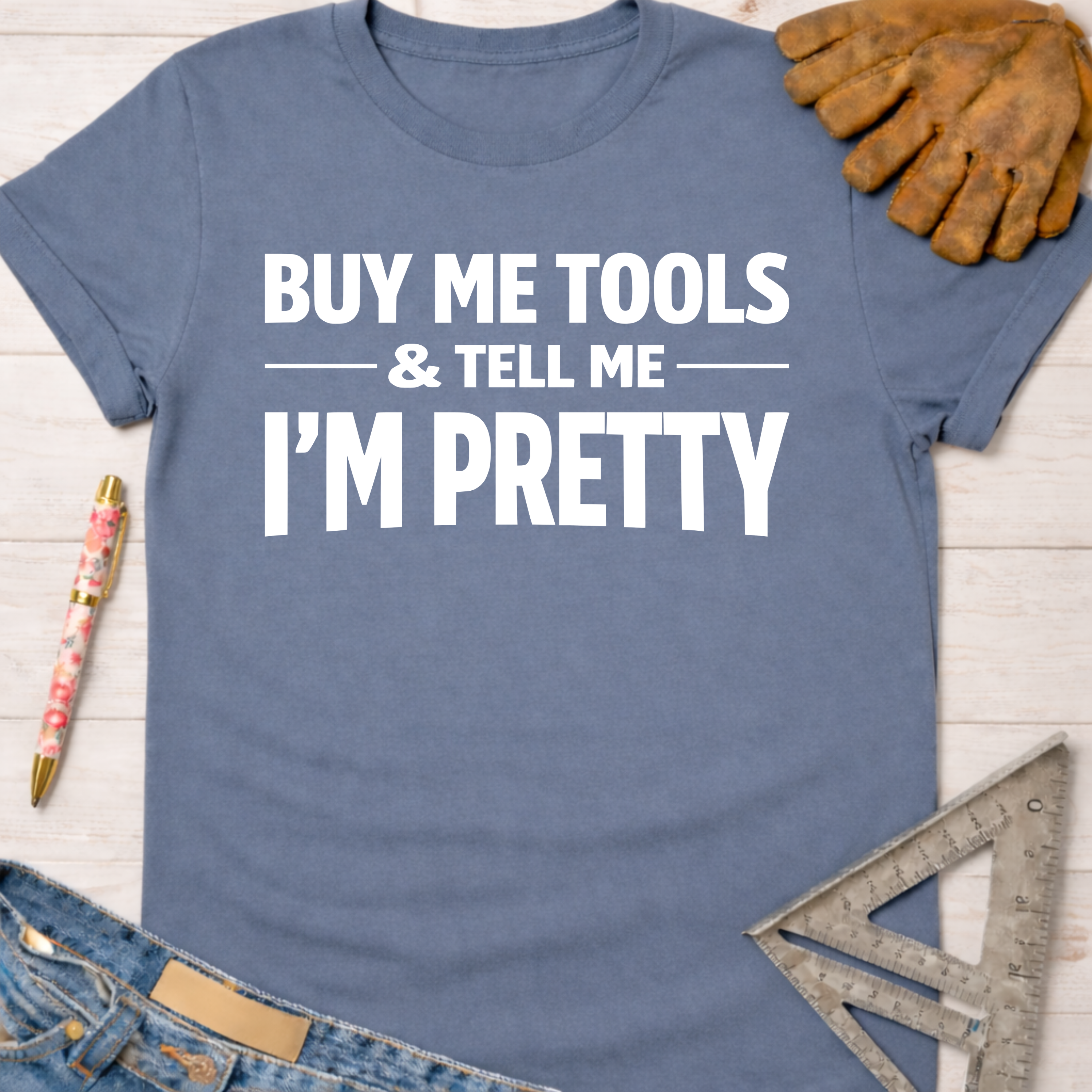 Women's funny woodworking graphic tee shirt for female woodworkers, makers, and DIY builders — Sawdust & Ponytails. Blue cotton tee with "BUY ME TOOLS & TELL ME I'M PRETTY" in white text.