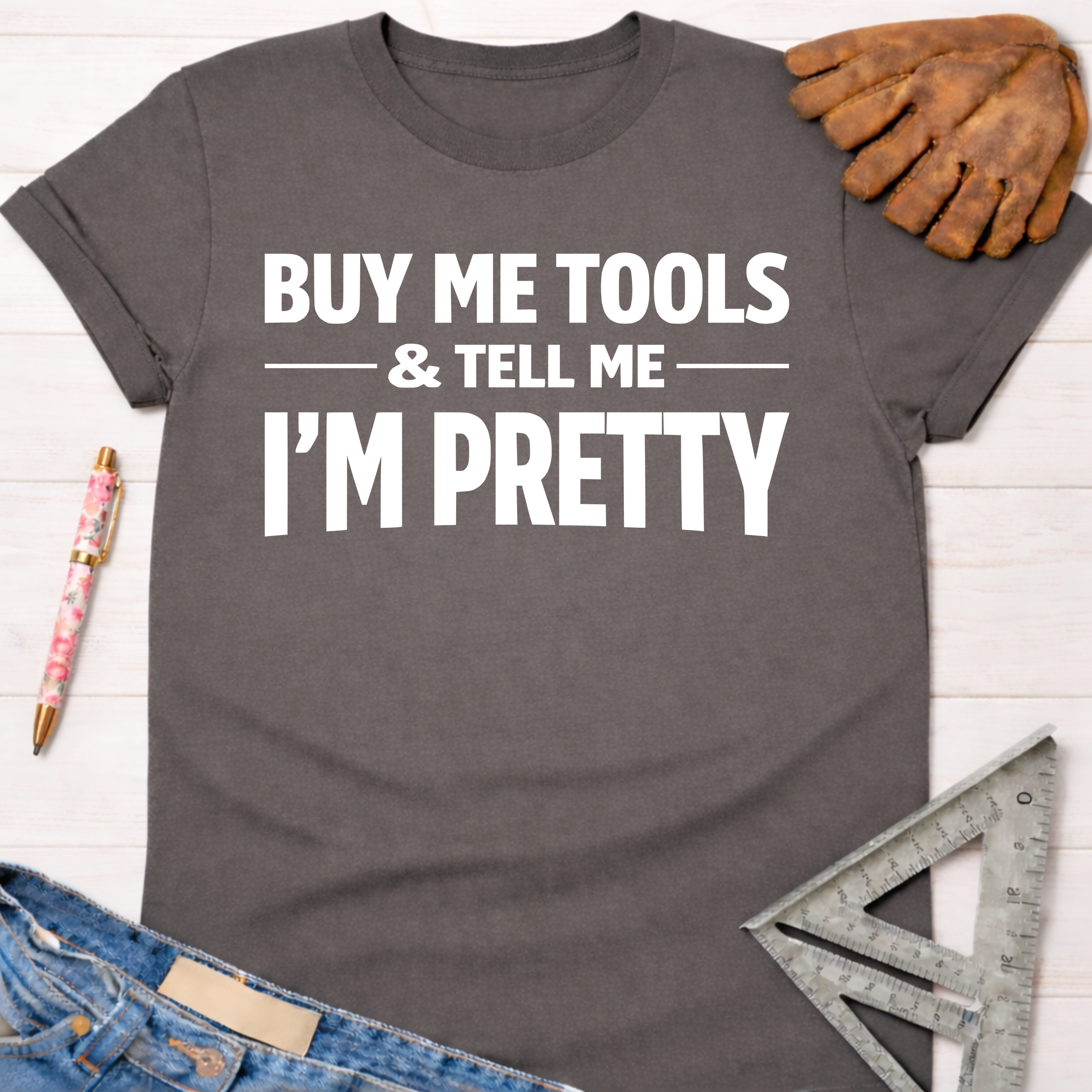 Charcoal grey graphic tee with "BUY ME TOOLS & TELL ME I'M PRETTY" in white text. Women's funny woodworking graphic tee shirt for female woodworkers, makers, and DIY builders — Sawdust & Ponytails.