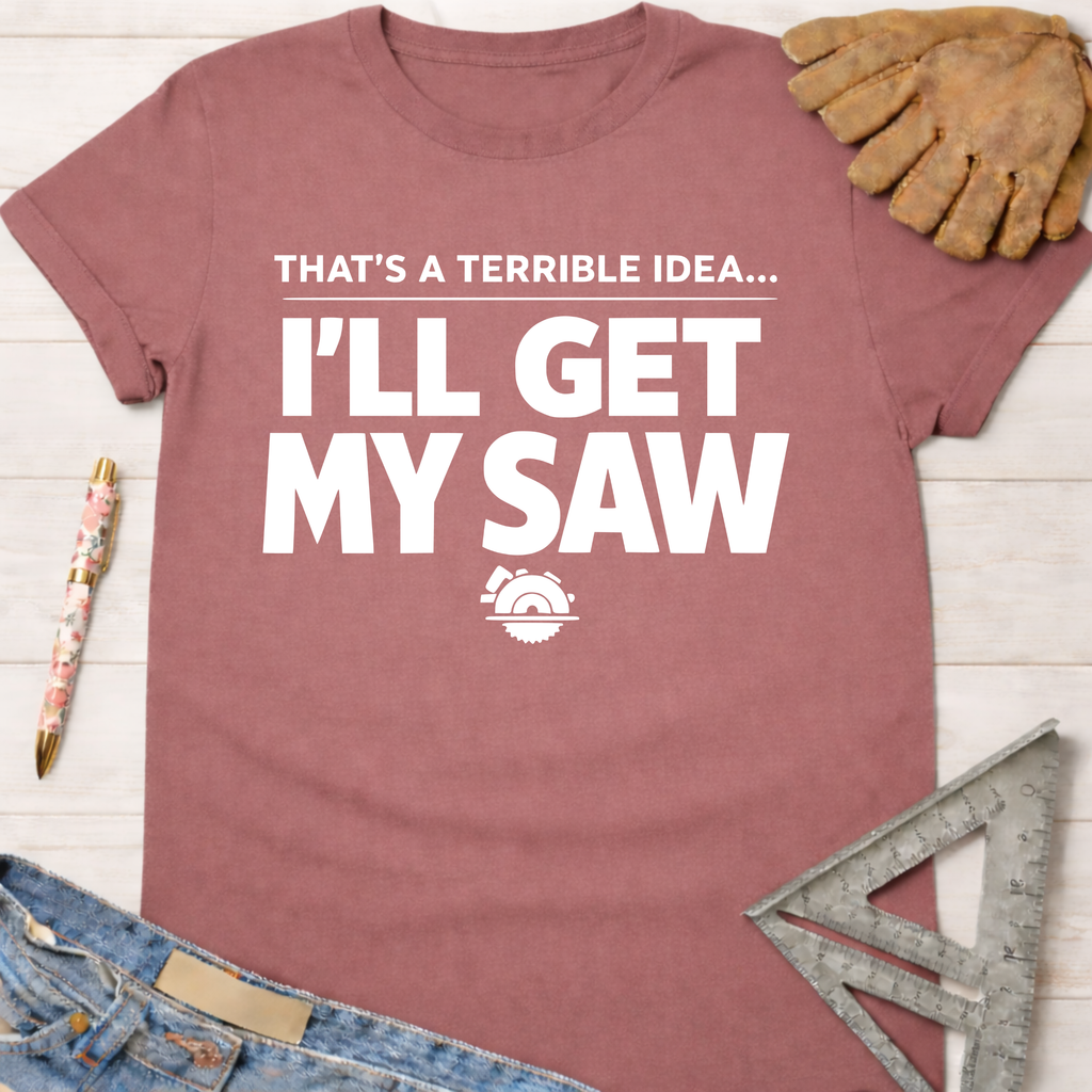 Women's funny woodworking graphic tee shirt for female woodworkers, makers, and DIY builders — Sawdust & Ponytails. Mauve cotton tee with "That's A Terrible Idea... I'll Get My Saw" text and saw blade graphic.