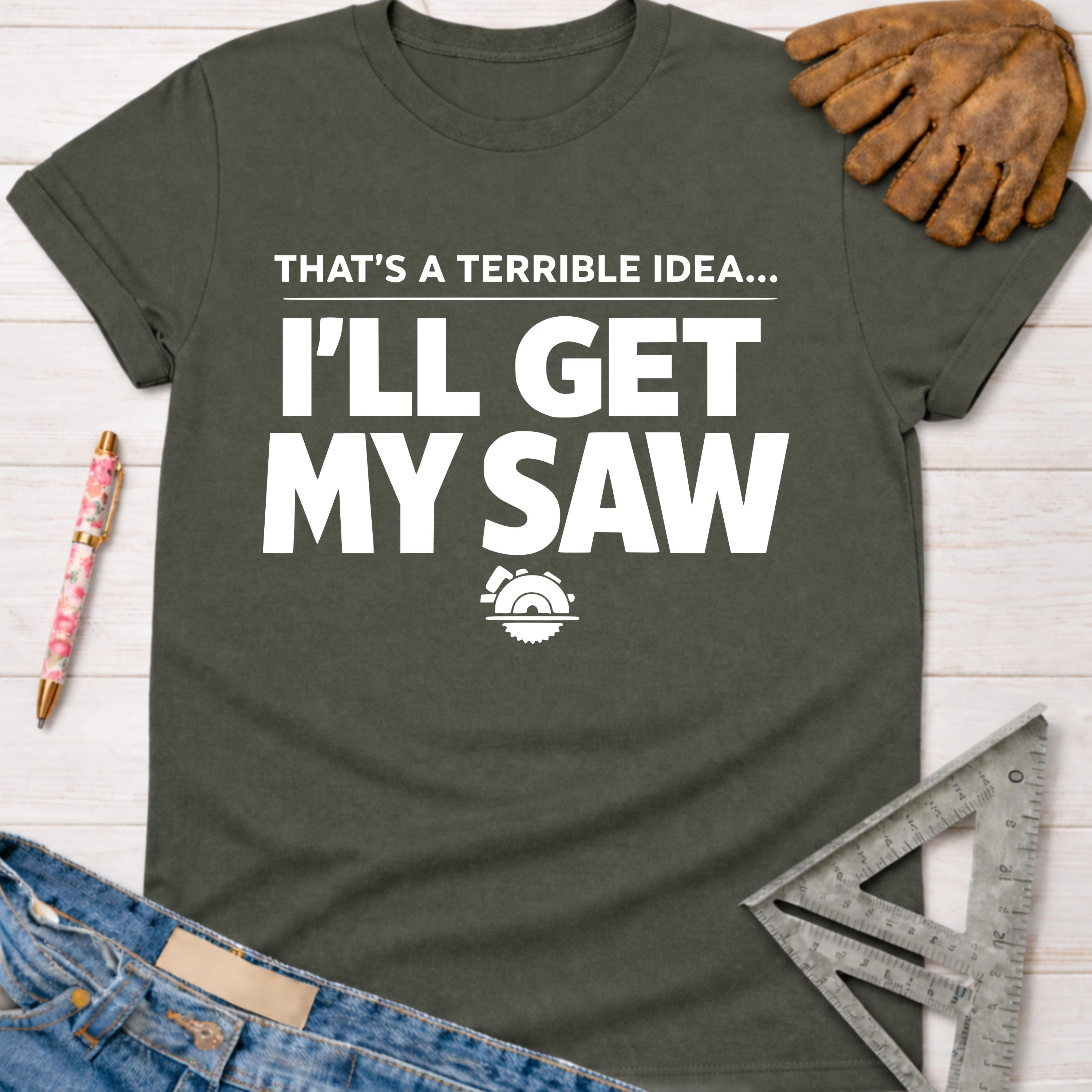 Women's funny woodworking graphic tee shirt for female woodworkers, makers, and DIY builders — Sawdust & Ponytails. Dark gray short-sleeve t-shirt with "THAT'S A TERRIBLE IDEA... I'LL GET MY SAW" in white text and a saw graphic.