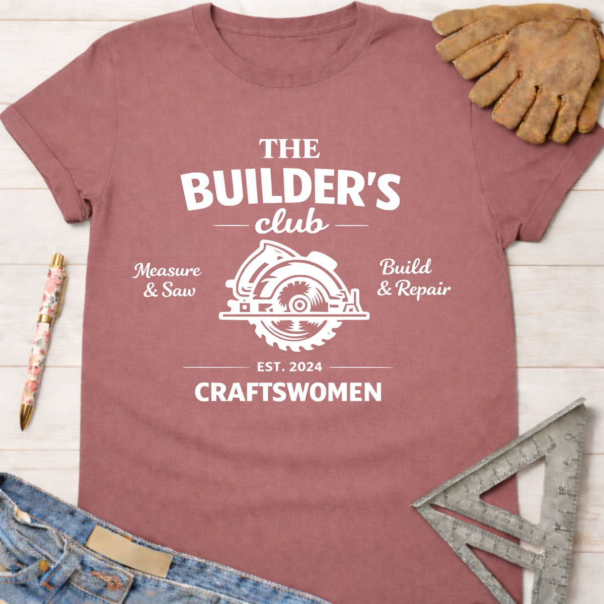 Women's funny woodworking graphic tee shirt for female woodworkers, makers, and DIY builders — Sawdust & Ponytails. Mauve cotton tee with "The Builder's Club" circular saw graphic.