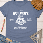 Women's funny woodworking graphic tee shirt for female woodworkers, makers, and DIY builders — Sawdust & Ponytails. Blue cotton tee with "The Builder's Club" graphic, circular saw, and "Craftswomen Est. 2024".