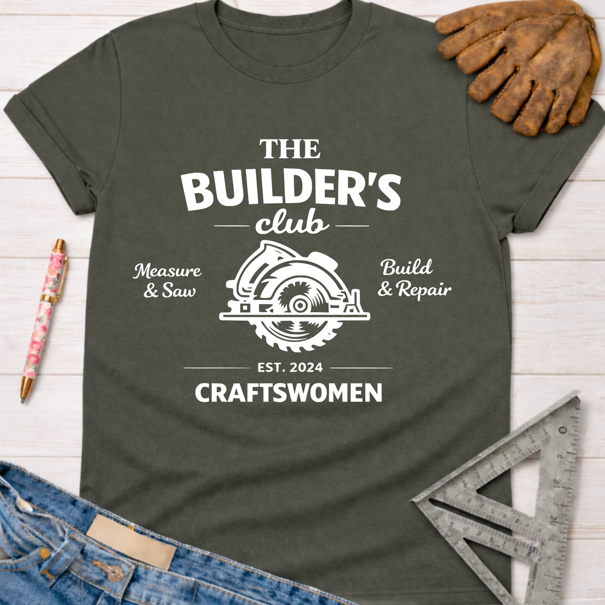 Women's funny woodworking graphic tee shirt for female woodworkers, makers, and DIY builders — Sawdust & Ponytails. Dark gray cotton tee with "The Builder's Club" circular saw graphic.