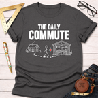 Dark gray cotton t-shirt with "THE DAILY COMMUTE" graphic showing a stick figure walking from a house to a workshop.