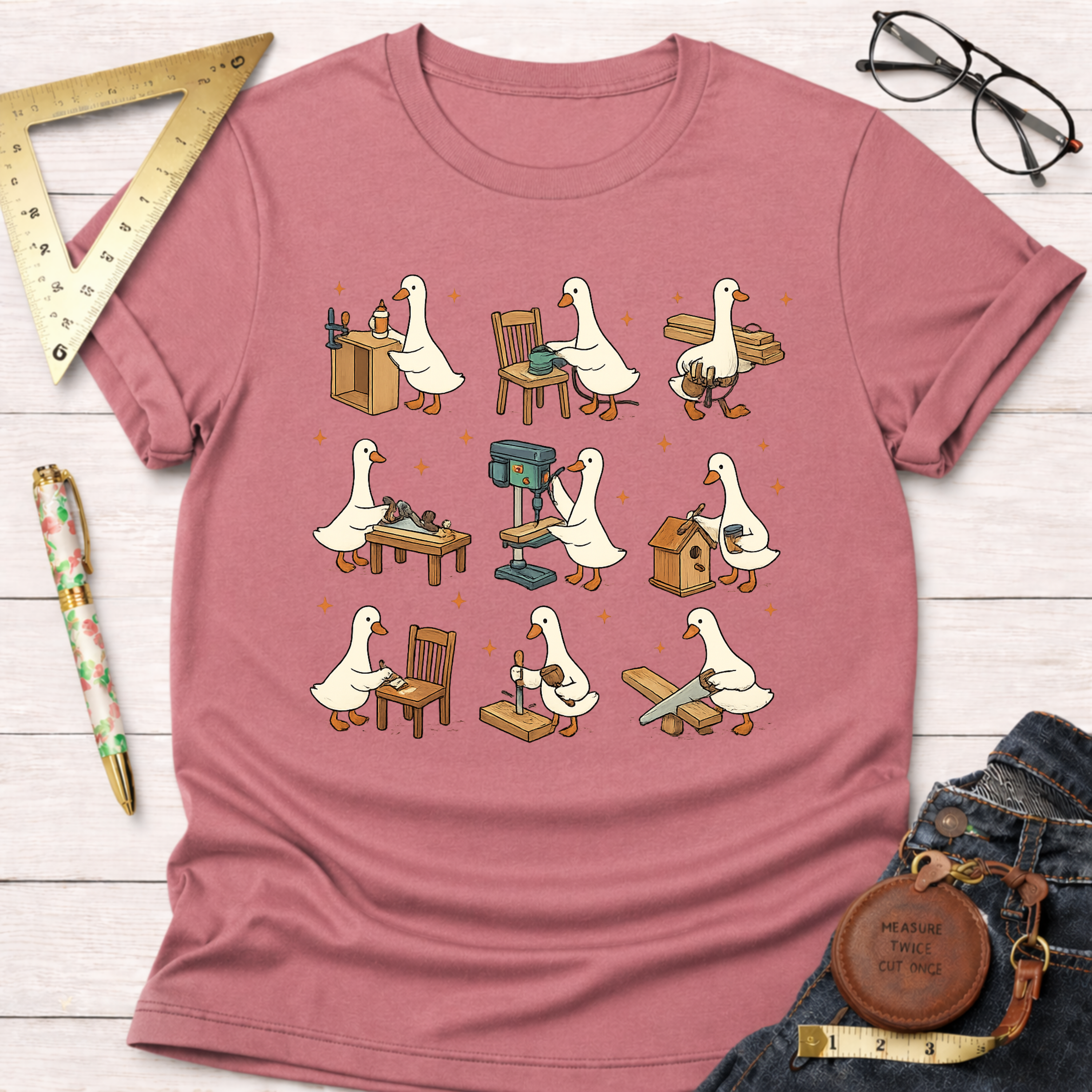 Women's funny woodworking graphic tee shirt for female woodworkers, makers, and DIY builders — Sawdust & Ponytails. Heather mauve t-shirt with cartoon geese building furniture and birdhouses.