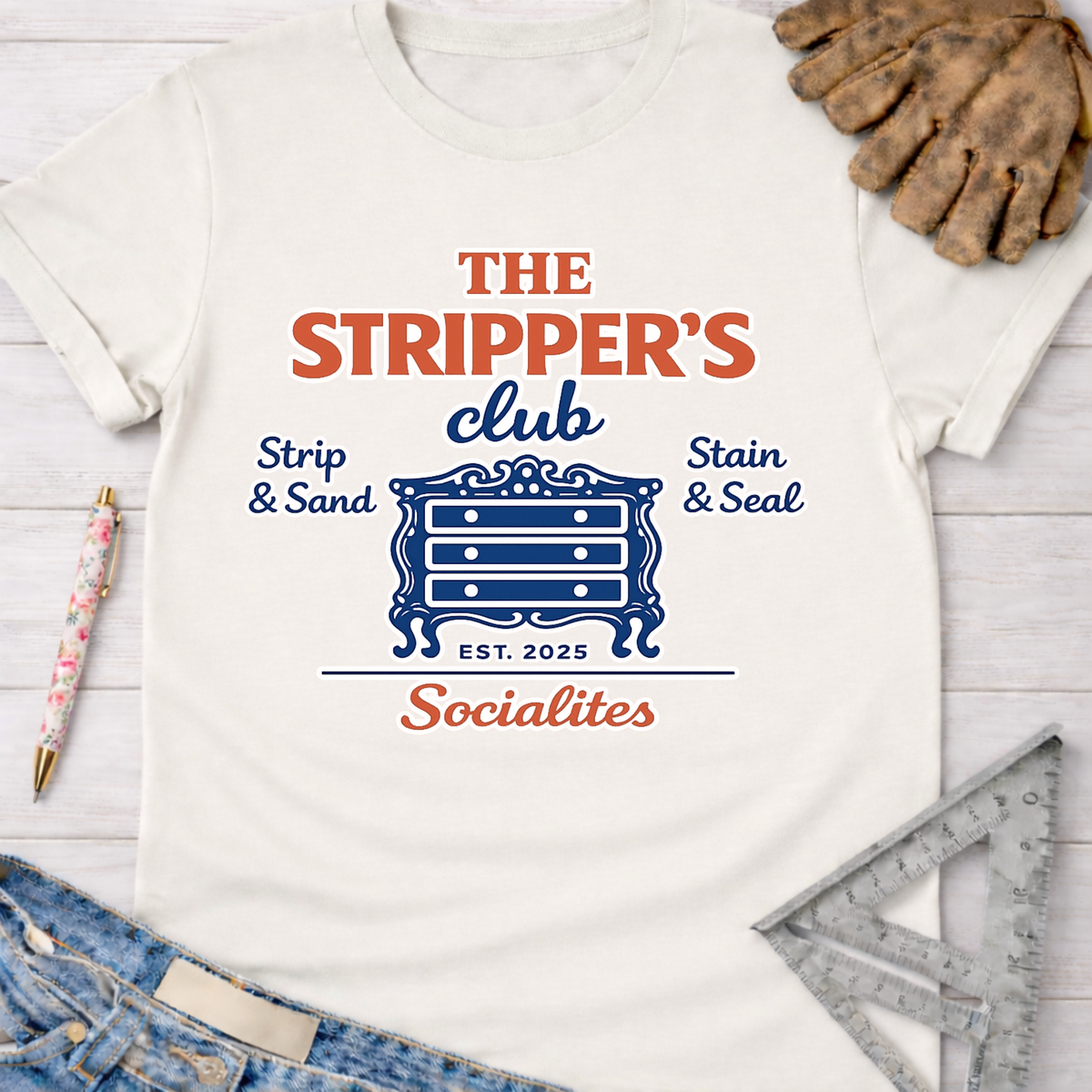 Women's funny woodworking graphic tee shirt for female woodworkers, makers, and DIY builders — Sawdust & Ponytails. White cotton tee with "The Stripper's Club Socialites" graphic featuring a blue dresser.
