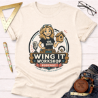 Women's funny woodworking graphic tee shirt for female woodworkers, makers, and DIY builders — Sawdust & Ponytails. Cream t-shirt with "Wing It Workshop Podcast" logo featuring a woman holding a birdhouse.