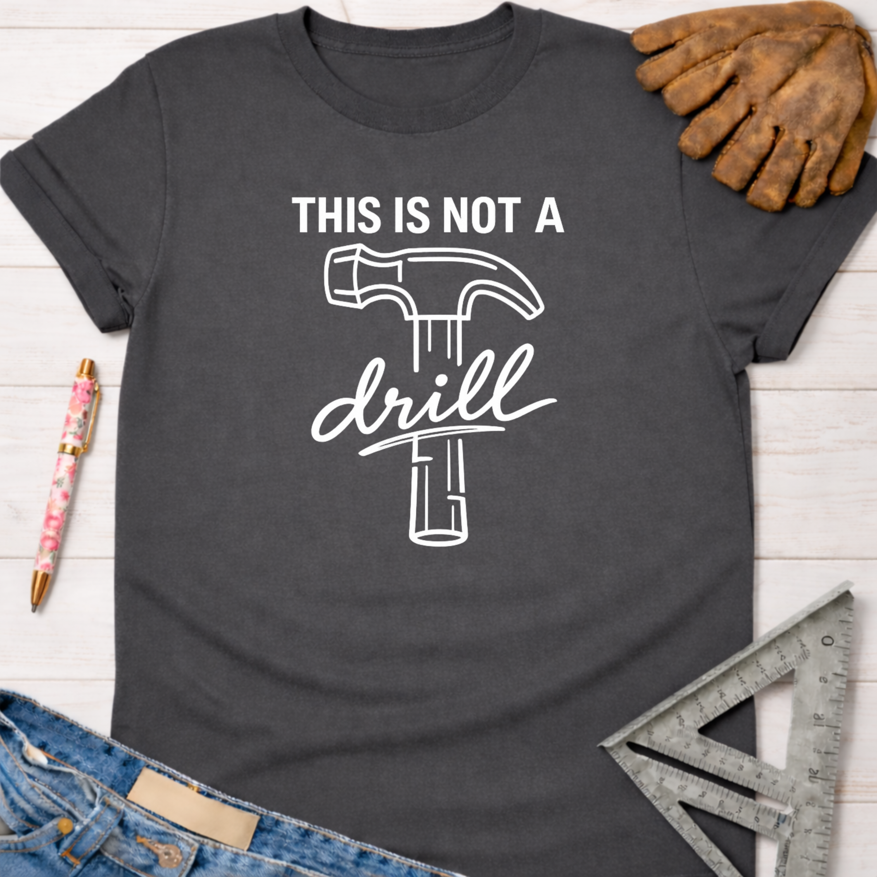 Women's funny woodworking graphic tee shirt for female woodworkers, makers, and DIY builders — Sawdust & Ponytails. Dark gray cotton tee with "THIS IS NOT A drill" text and hammer graphic.