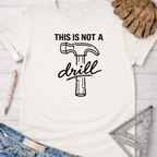 Women's funny woodworking graphic tee shirt for female woodworkers, makers, and DIY builders — Sawdust & Ponytails. White cotton tee with "THIS IS NOT A drill" text and hammer graphic.