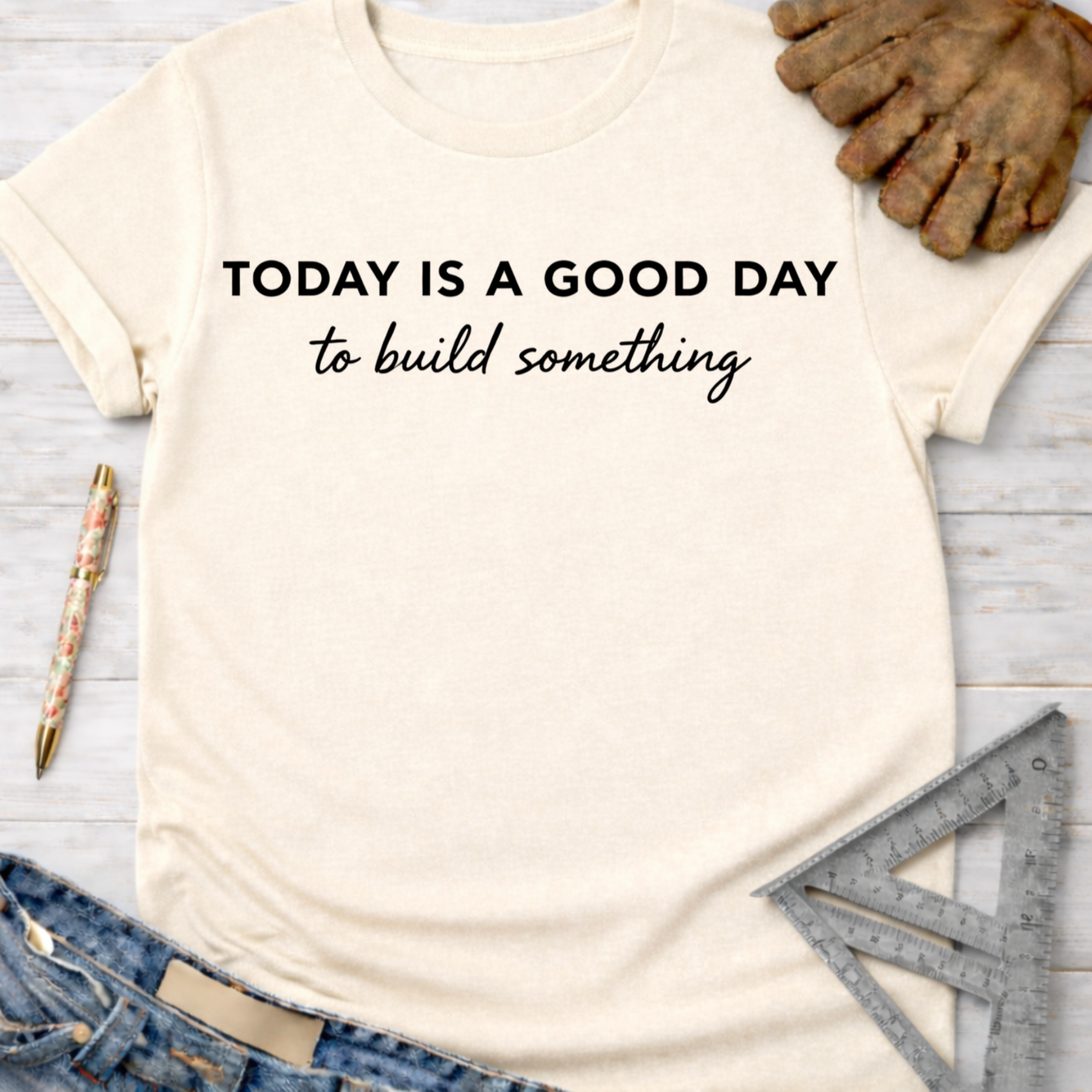 Women's funny woodworking graphic tee shirt for female woodworkers, makers, and DIY builders — Sawdust & Ponytails. Cream t-shirt with "TODAY IS A GOOD DAY to build something" text.